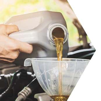 Basic Car Maintenance and Servicing Checklist | Performance Chevrolet | Close-up of mechanic refilling engine oil