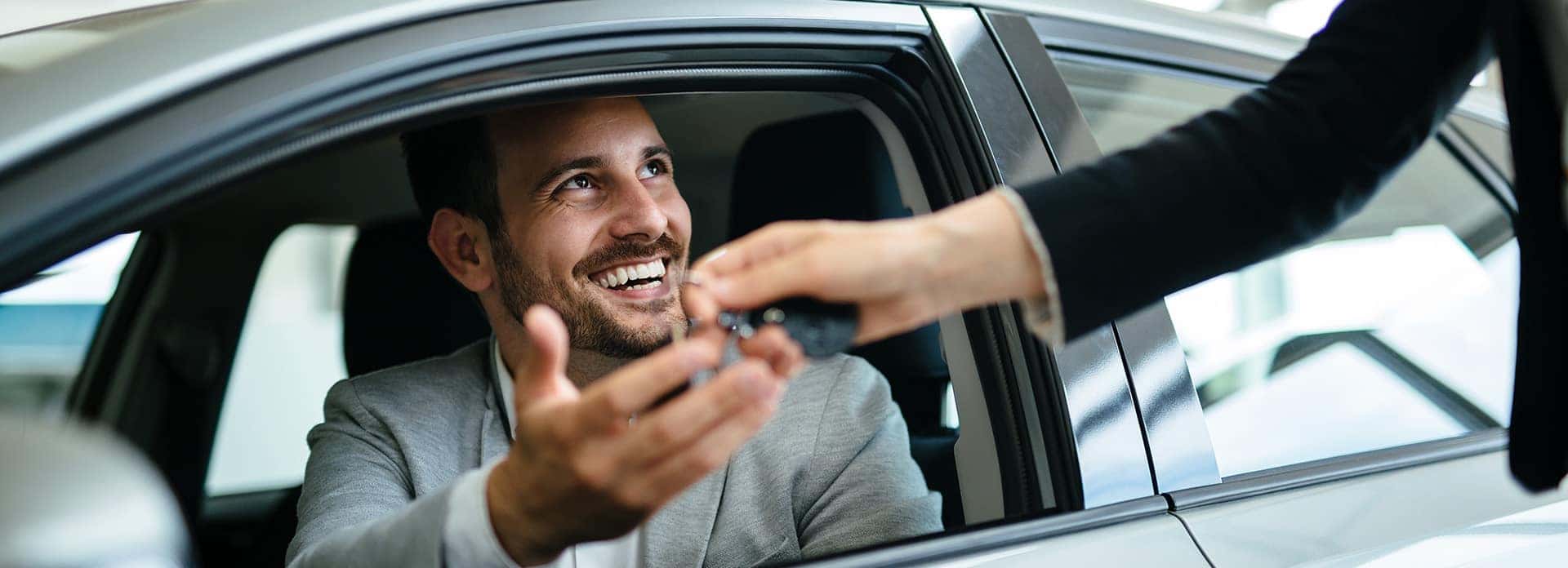 Defining GAP Insurance at Performance Chevrolet in Elizabeth City, NC | Customer Talking to Sales Advisor While Sitting in Vehicle on Sales Floor
