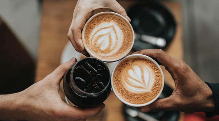 Performance Chevrolet is a Car Dealership in Elizabeth City, NC | Three People Holding Cups of Coffee In Cafe