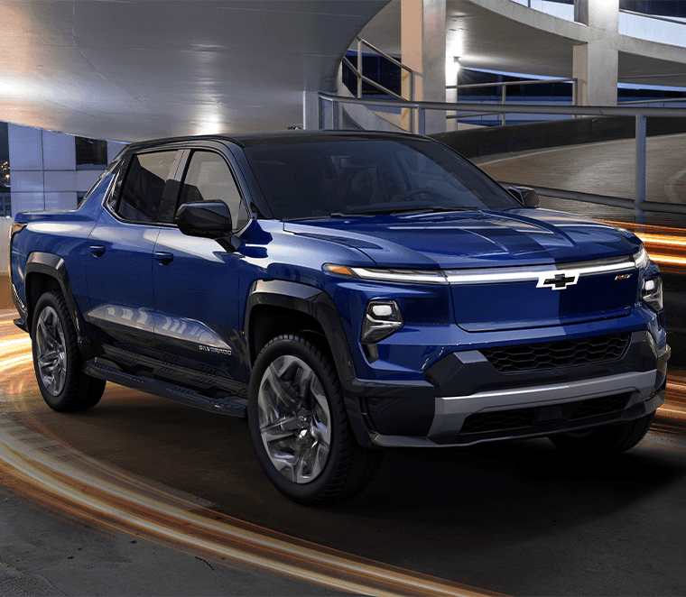 Chevrolet EV’s at Performance Chevrolet | Navy Blue 2023 Chevrolet Silverado EV driving down a parking garage 