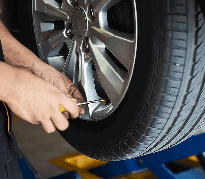 Tire Pressure Information at Performance Chevrolet in Elizabeth City, NC | Mechanic using a tool to let air out of tire valve