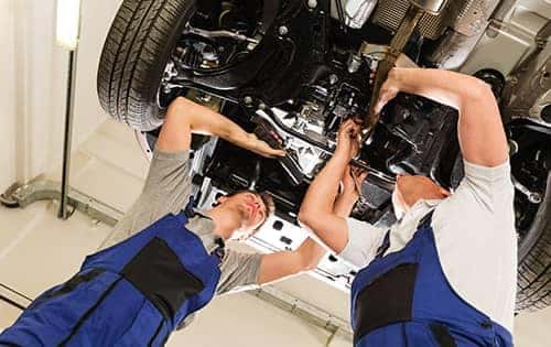 2 Mechanics looking underneath a car