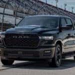 RAM 1500 pickup truck parked on a racetrack in front of grandstands.