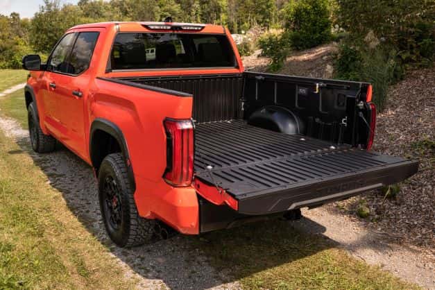 A Toyota Tundra parked in a field with the tailgate open