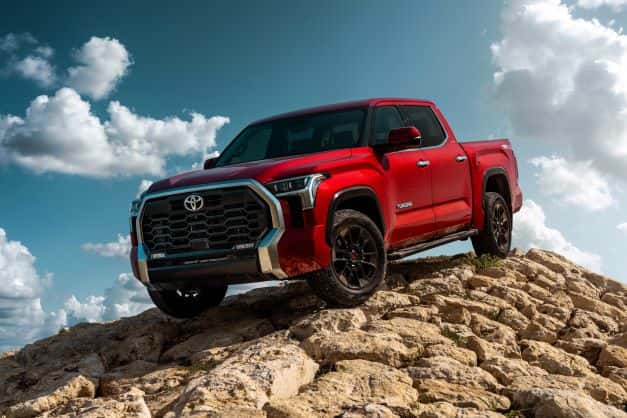 A red Toyota Tundra going downhill on a pack of rocks