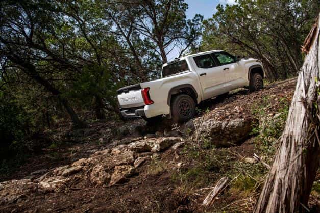 A white Toyota Tundra TRD Pro going off roading in the forest