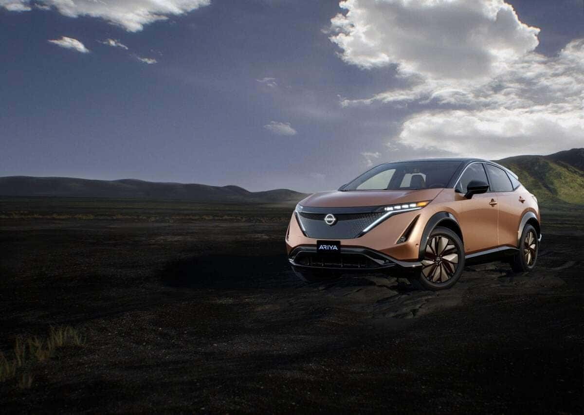 Man in suit walking toward red Nissan